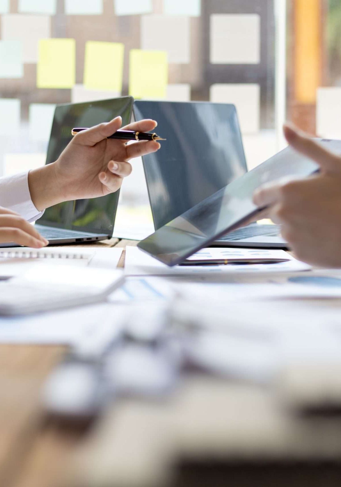 Business meeting, brainstorming sessions discuss analysis of investment growth graph and market charts in financial reports and business investment strategy planning.